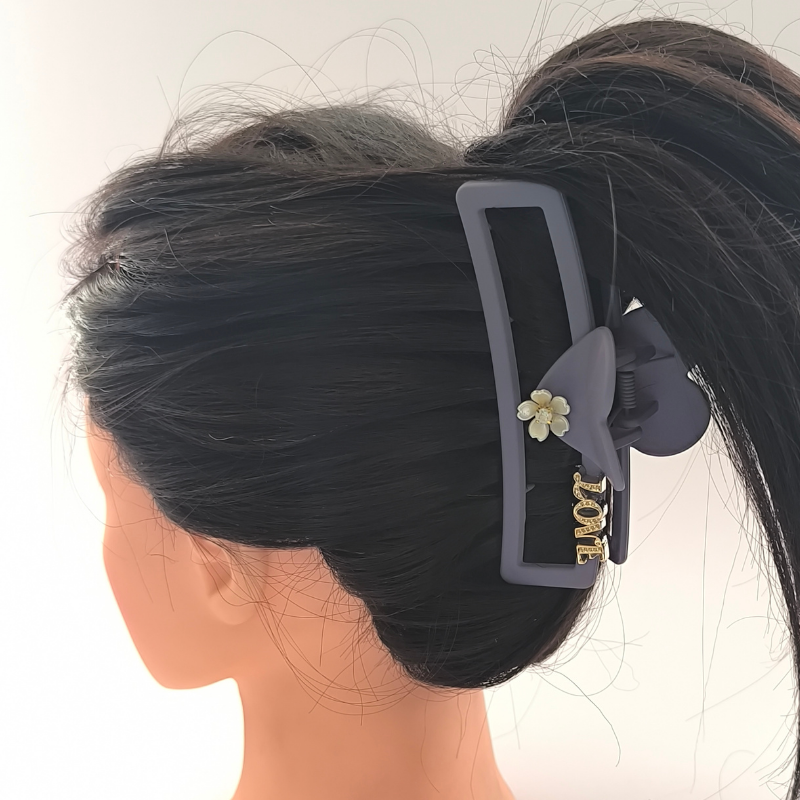 Pirana rectangular Love gris mate puesta en cabello largo oscuro recogido