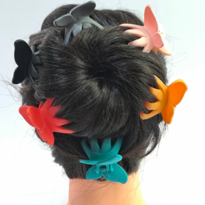 Multiples piranas mariposa mate en distintos colores puestas en recogido cabello oscuro